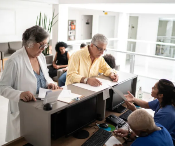 Accueil d'un patient dans le hall d'une clinique : discussion avec le personnel d'accueil