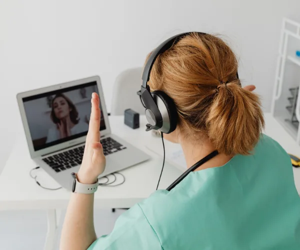 Téléconsultation : soignante avec casque devant un ordinateur