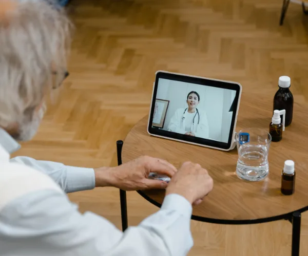 Patient âgé en téléconsultation sur tablette à son domicile
